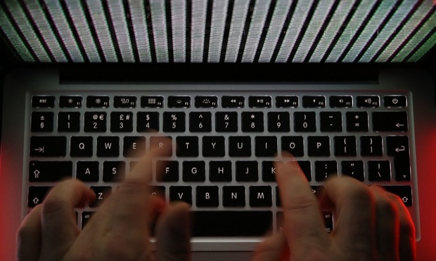 A close-up of hands typing on a black computer keyboard.