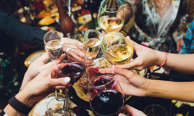 A group of people clink their wine glasses together in a toast.