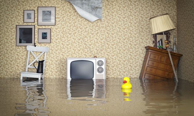Common household items are shown amongst standing water in a flooded house.