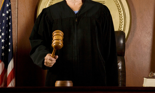A shot from the neck-down of a judge holding a gavel.