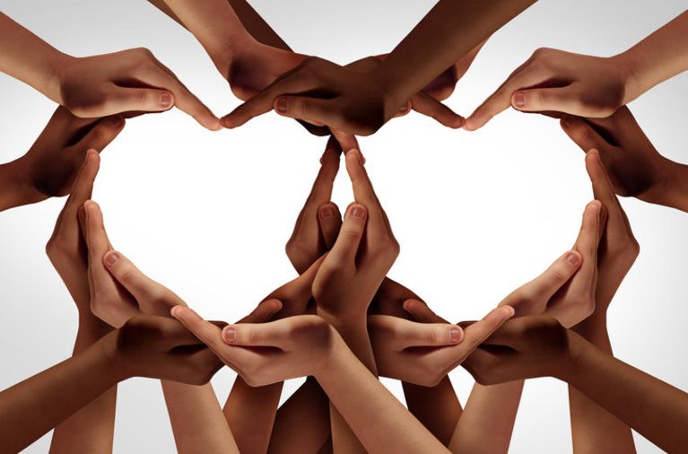 Several hands coming together to form two hearts