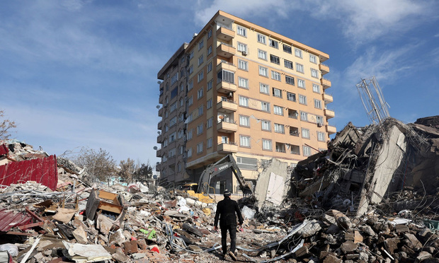 A man walks across the rubble of collapsed buildings in Kahramanmaras, Turkey on February 7, 2023. 