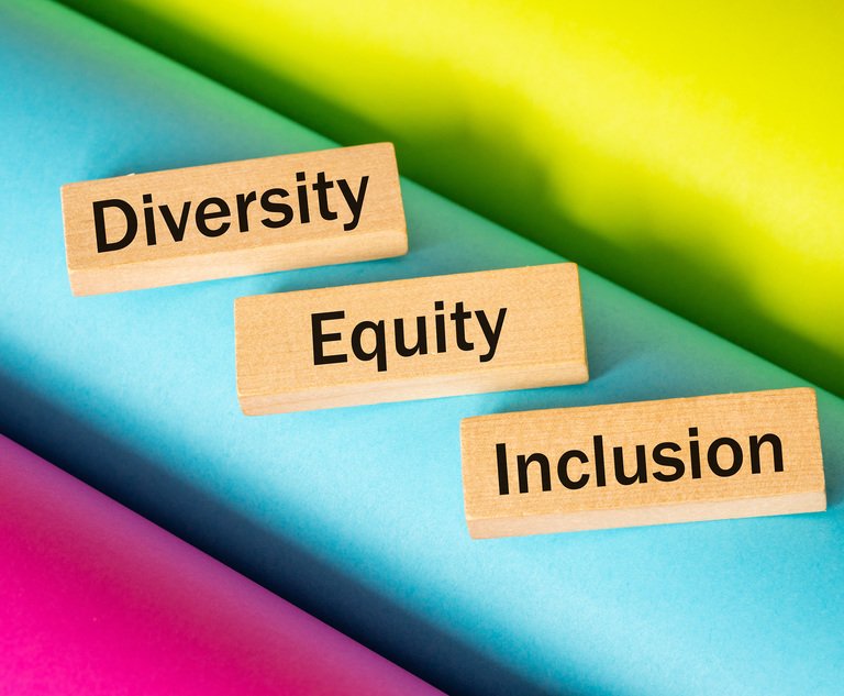Three wooden blocks reading "diversity," "equity" and "inclusion" sit on top of a multicolored background.