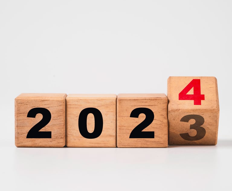 A line of wooden blocks reading "2023." The last block is rolling over from "3" to "4" to signify the changing year.