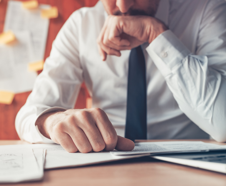 A business person sitting at a desk, looking worried.