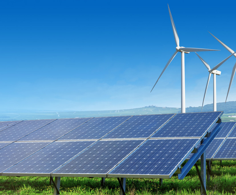 solar panels and wind turbines under blue sky