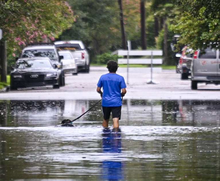 A man walks on a flooded street due to Tropical Storm Debby on Aug. 6 in Charleston, South Carolina. (Photo Credit: Miguel J. Rodríguez Carrillo/Getty Images North America)