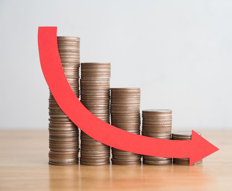 Stacks of coins of descending size with an arrow overlaid showing the downward trend.