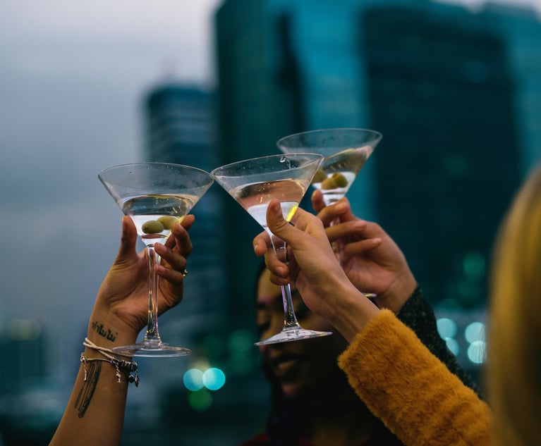 Three people clinking martini glasses together