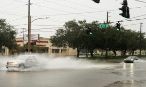 Vehicles passed through a watery intersection in St. Petersburg, Fla., on Wed., Oct. 9, 2024, as Hurricane Milton continued to develop over the Gulf of Mexico. The storm is expected to bring record-high surge flooding to the region, which is still recovering from September's Hurricane Helene. (Photo: Tristan Wheelock/Bloomberg)